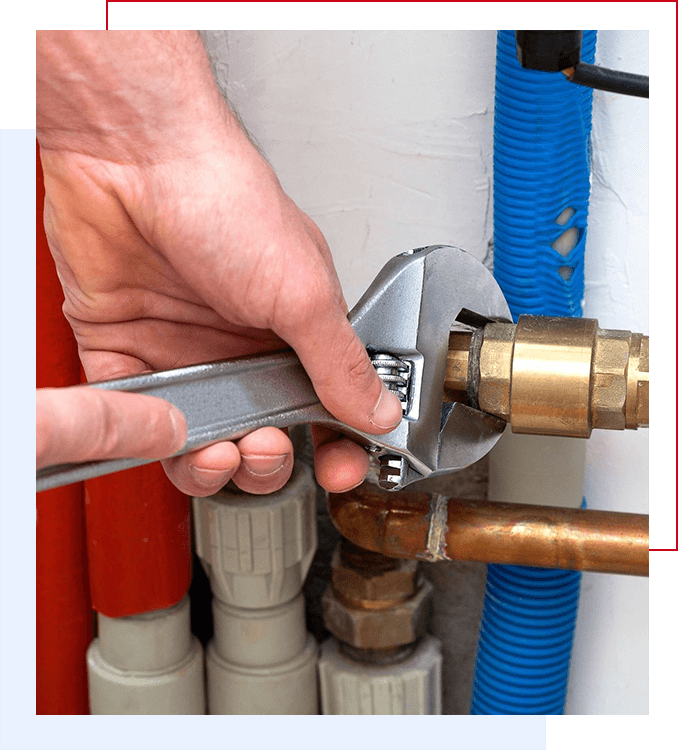 A person is holding a wrench and adjusting the water pipes.